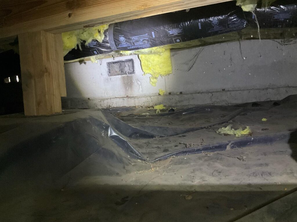 A foundation vent that a raccoon damaged to enter